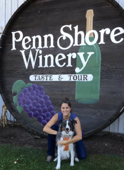 Young Lady with Dog In Front of Winery Sign