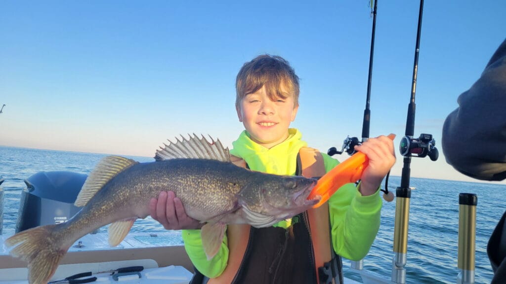 Youngster on a boat with a walleye caught on Lake Erie