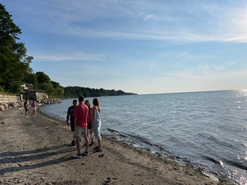 Adults standing at the shoreline of Woodmere Beach, in North East PA